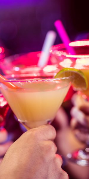 Group of friends toasting cocktail at bar counter in bar